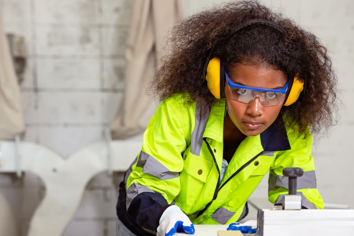 Noise Awareness In Practice - Worker Wearing Ear Defenders When Using Machinery