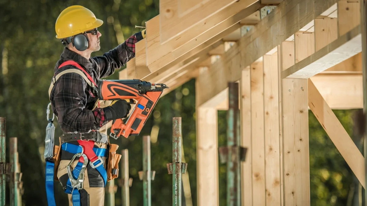 Site Carpenter Using A Framing Nailer To Fix Roofing Joists