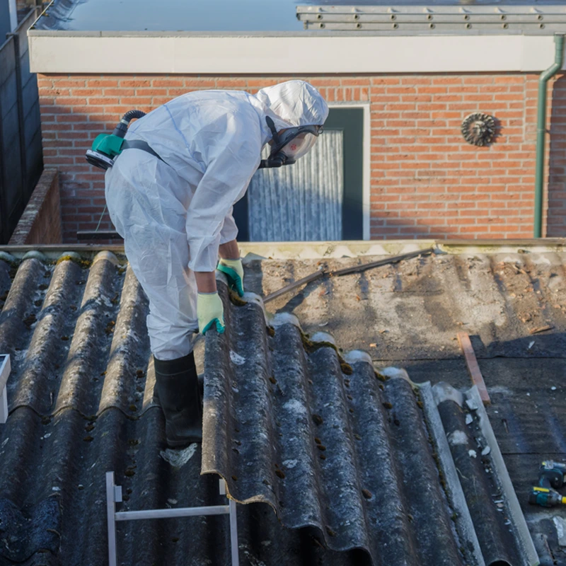 Worker Removing Asbestos Sheeting From A Roof