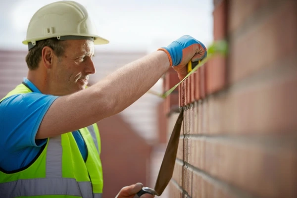 Bricklayer building a brick wall on a construction site