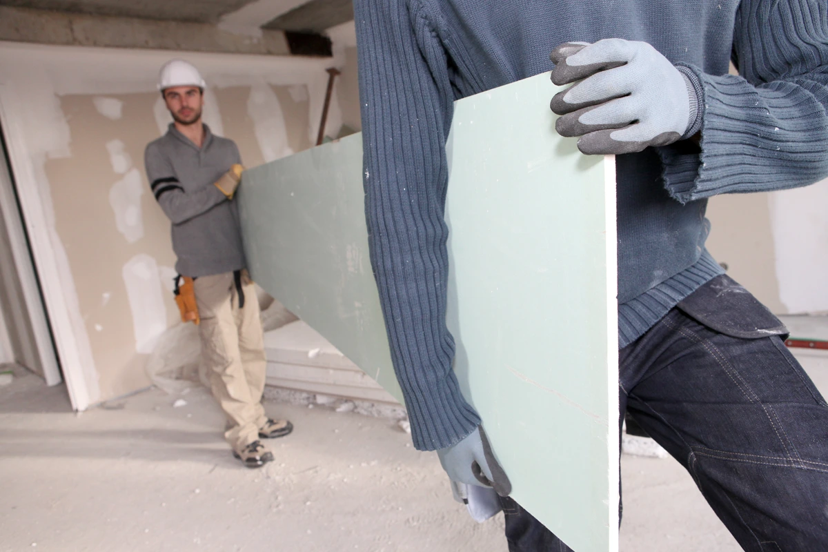 Two Dry Lining Boarders Carrying Board